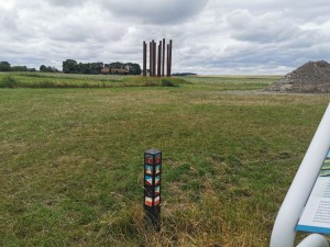 Wandelknooppuntpaal met gekleurde routebordjes.