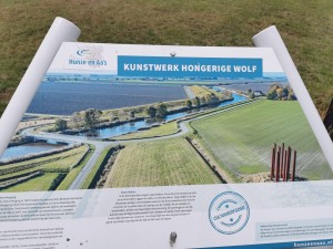 Informatiebord over kunstwerk Hongerige Wolf.