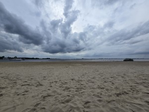 Uitgestrekt zandstrand aan het water.